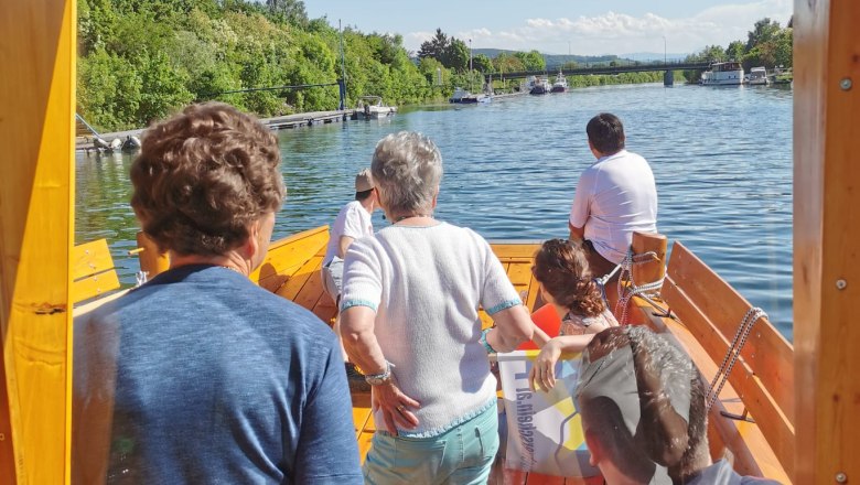 View from a boat on a river with several people on board.
