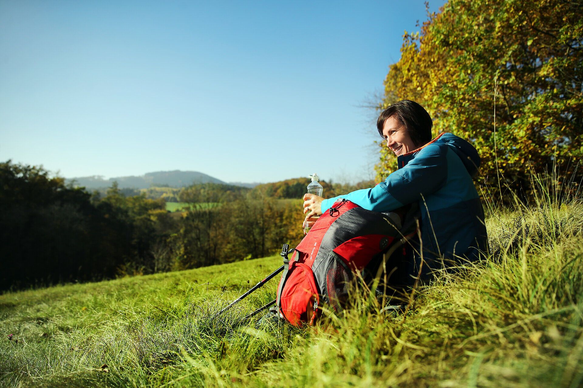 In der malerischen Landschaft des Melker Alpenvorlands genießt ein Wanderer eine wohlverdiente Pause. Umgeben von sanften Hügeln und strahlend blauem Himmel, erfrischt er sich mit einem Getränk und lässt die Schönheit der Natur auf sich wirken. Diese Idylle lädt dazu ein, die Seele baumeln zu lassen und die frische Bergluft zu genießen.