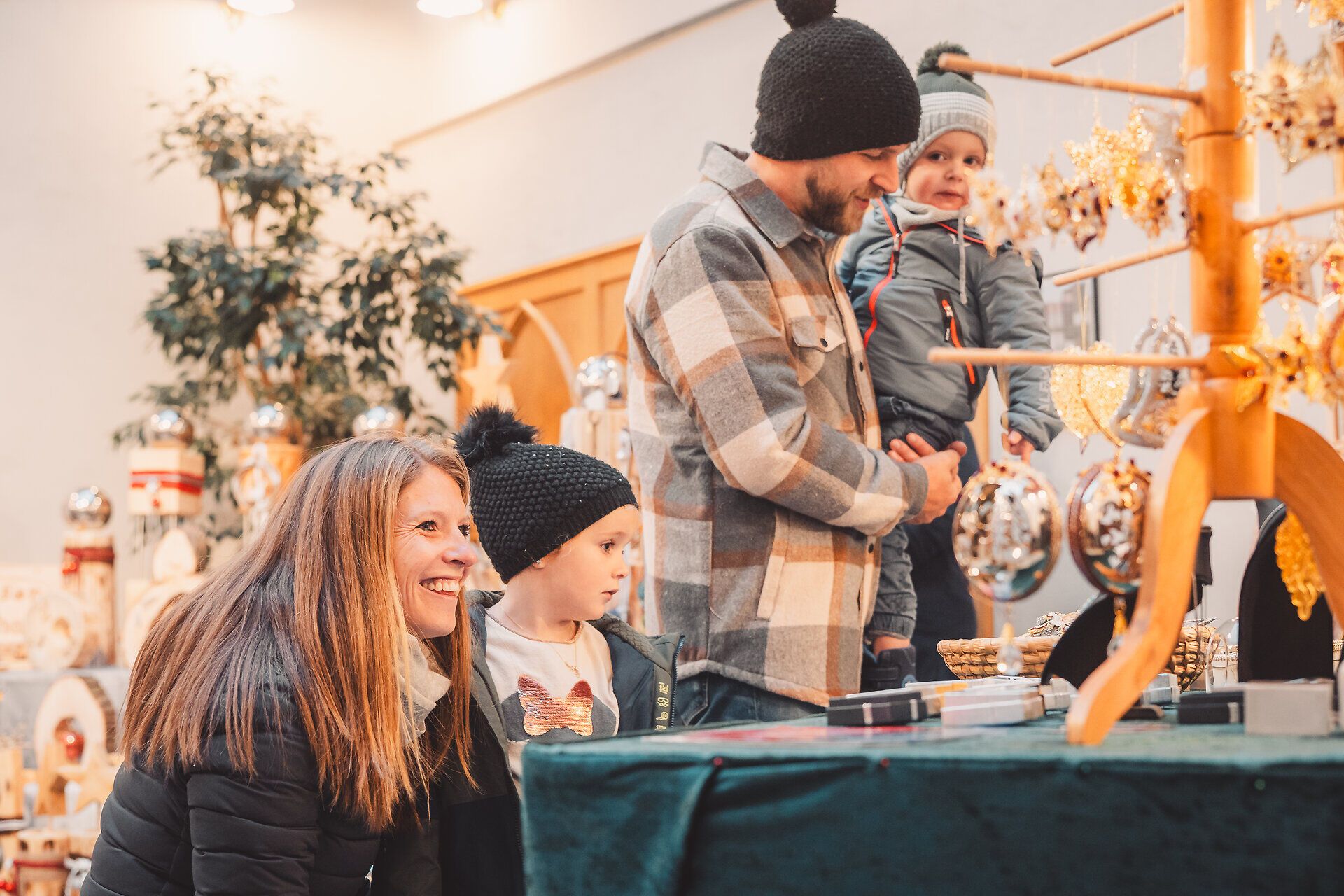 Familie bestaunt die handgefertigten Stücke auf dem Adventmarkt in Scheibbs.
