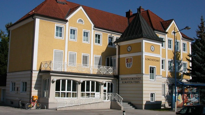 Gelbes Gebäude des Gemeindeamts Kematen an der Ybbs mit Uhr und Wappen.