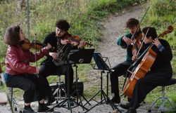 Apeiron Quartet bei der Performance im Rahmen der Gipfelklänge.
Das Streicherquartett mit Geige, Violine, Cello und Bratsche spielt klassische Musik unter freiem Himmel – ein besonderer Moment in den Alpen.