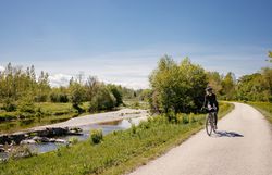 Ein malerischer Radweg schlängelt sich entlang eines sanft plätschernden Baches, umgeben von üppigem Grün und blühenden Wiesen. Die klare Luft und die strahlende Sonne laden dazu ein, die Schönheit der Natur zu genießen und die Seele baumeln zu lassen.