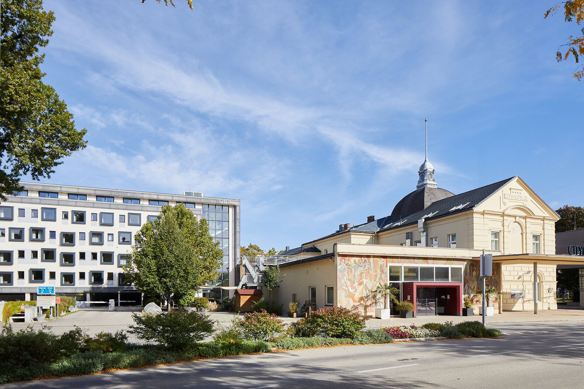 Die harmonische Verbindung von modernem Design und historischer Architektur schafft eine einladende Atmosphäre. Umgeben von üppigem Grün und blühenden Pflanzen, lädt dieser Ort zum Verweilen und Entspannen ein. Genießen Sie die Ruhe und die Schönheit der Umgebung in dieser charmanten Stadt.