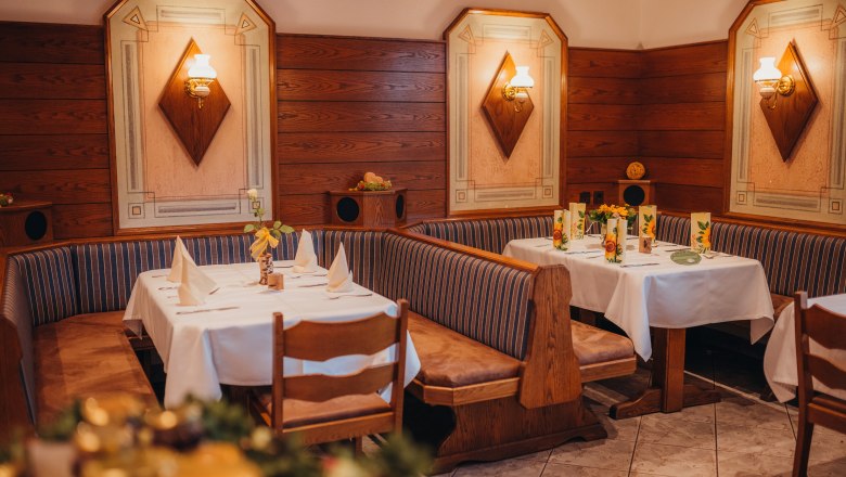 Gemütliches Restaurant mit Holzwänden und dekorierten Tischen.