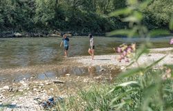 Personen waten durch die seichte Ybbs an einer Kiesbank.