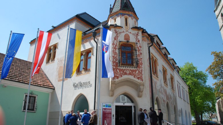 Historisches Rathaus in Haag mit bemalter Fassade und Flaggen davor.