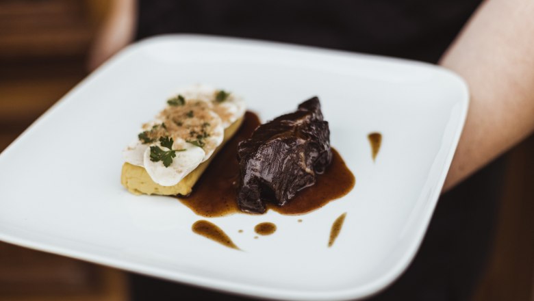 Ein Teller mit Rindsbackerl in Sauce und Champignons auf Erdäpfel-Soufflé.