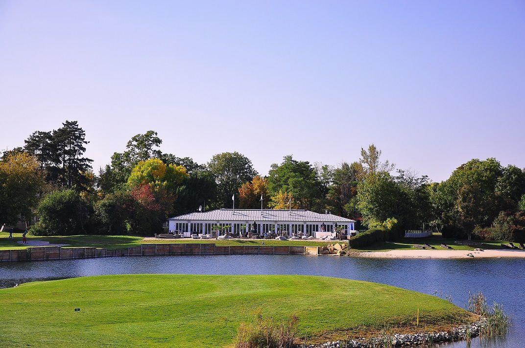 Gebäude am See im Diamond Country Club umgeben von Bäumen.