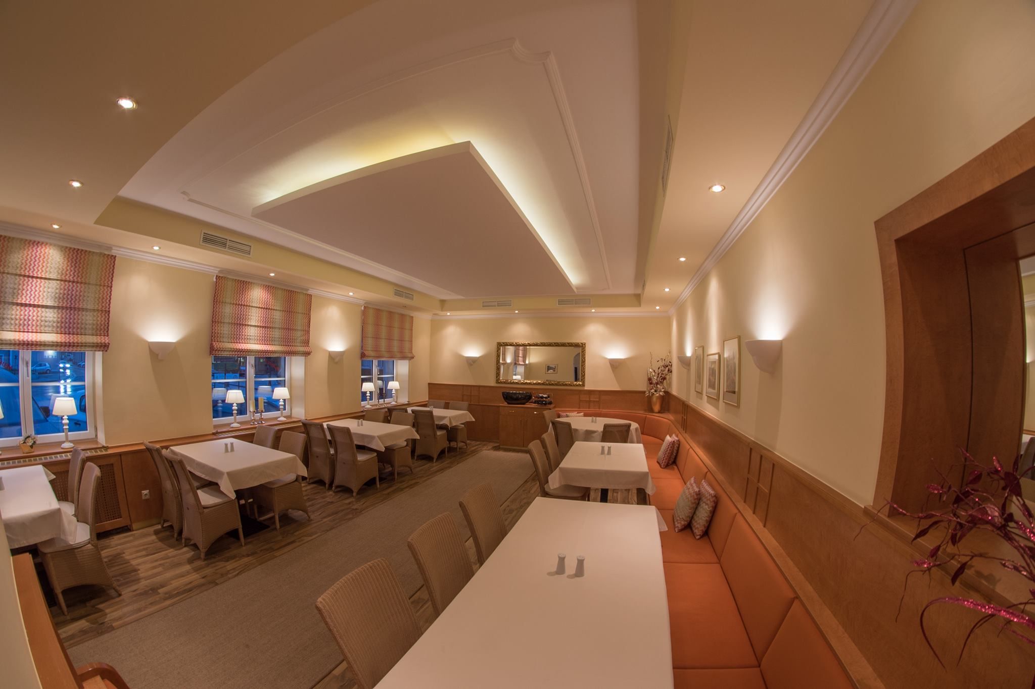 Elegantes Restaurant mit gedeckten Tischen, warmem Licht und stilvoller Dekoration.