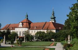 Luftaufnahme des Benediktinerstifts Seitenstetten umgeben von grünen Feldern und Hügeln.