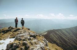 Zwei Wanderer stehen am Gipfel und genießen den atemberaubenden Blick über die Ybbstaler Alpen. Die frische Bergluft und die majestätischen Landschaften laden dazu ein, die Seele baumeln zu lassen und die Schönheit der Natur zu erleben.