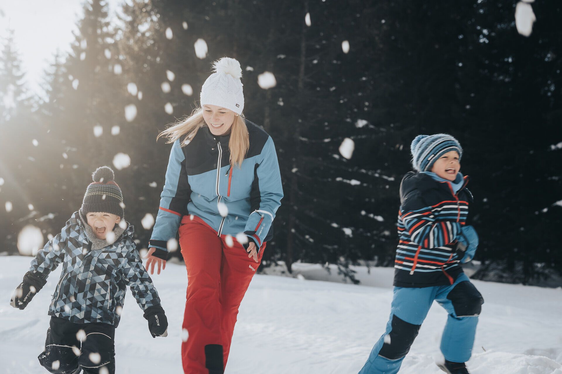 Eine fröhliche Familie genießt den Winter in den Ybbstaler Alpen, während sie sich in einer lebhaften Schneeballschlacht vergnügt. Die strahlenden Gesichter der Kinder und die schneebedeckte Landschaft schaffen eine unvergessliche Atmosphäre voller Freude und Abenteuer.