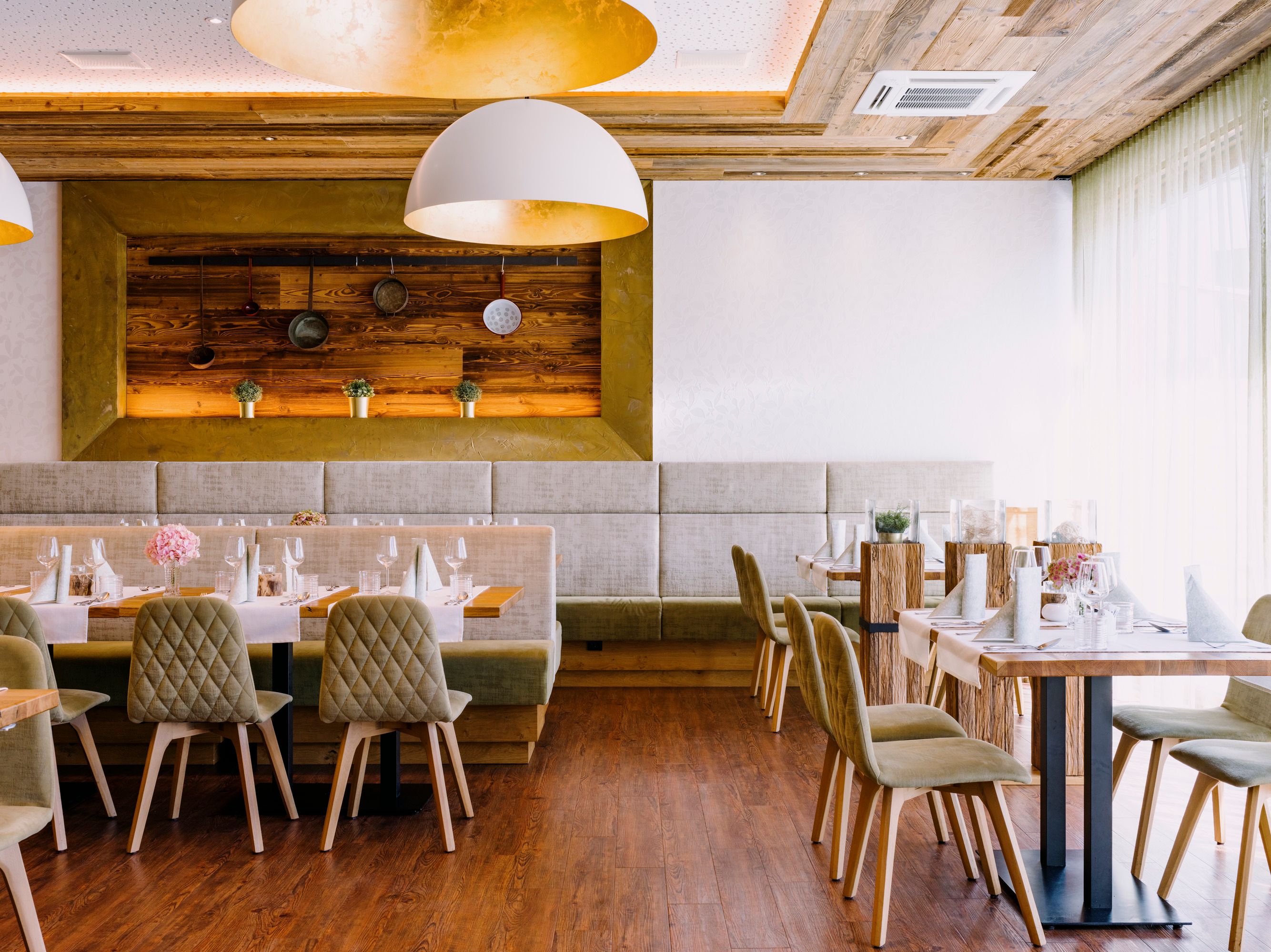 Modernes Restaurant mit Holzelementen und eleganter Tischdekoration.