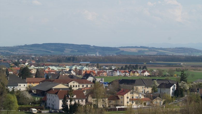 Panoramablick auf Ennsdorf mit Häusern und Hügeln im Hintergrund.