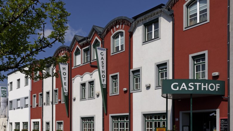 Außenansicht des Restaurant-Hotels Wallner mit roter und weißer Fassade.