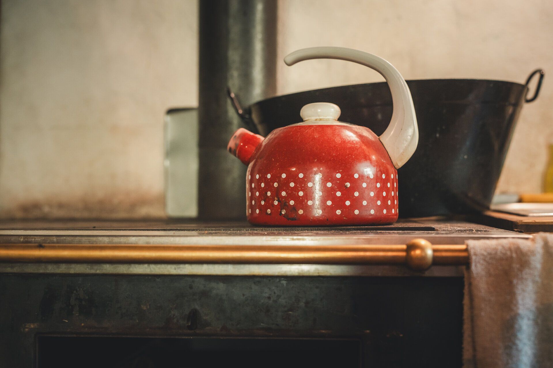 Rustikaler Teekessel auf Holzofen in der Herrenalm Hütte.