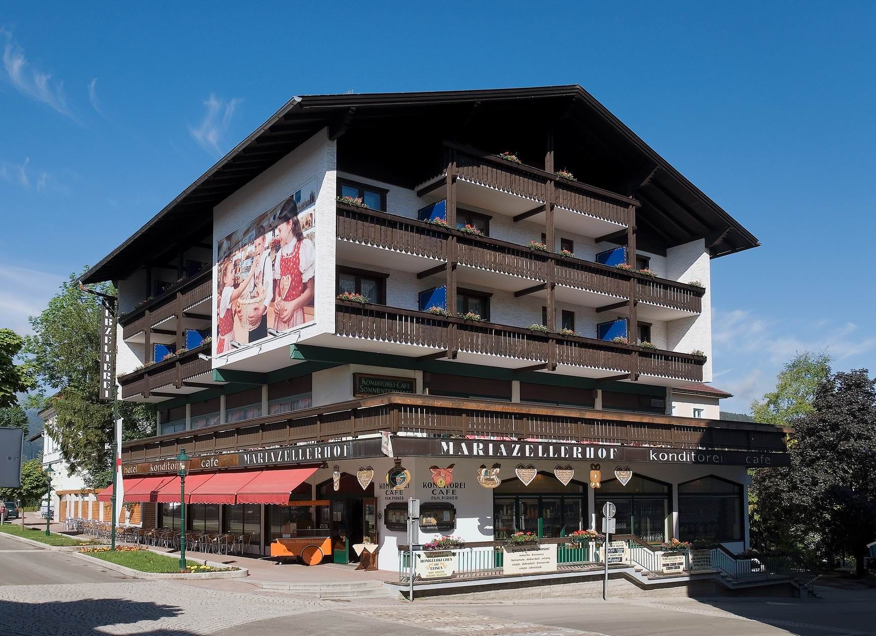 Außenansicht des Hotel Pirkers Mariazellerhof mit Balkonen und Café.