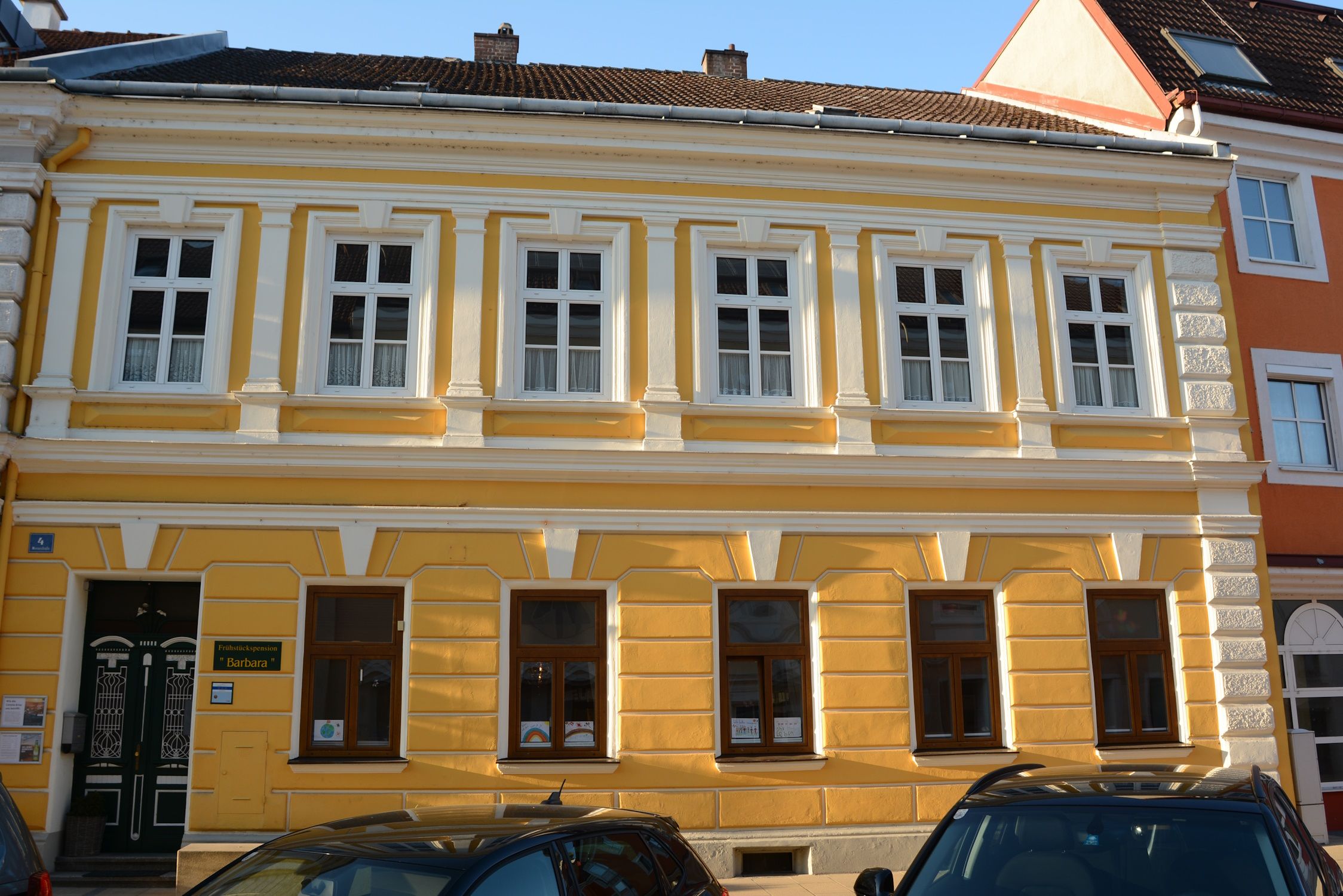Gelbes Gebäude mit weißen Fensterrahmen und dekorativen Elementen in Pöchlarn.
