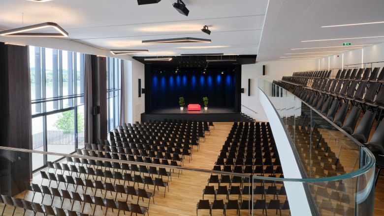 Interior view of Stadthalle Ybbs with empty rows of seats and stage.