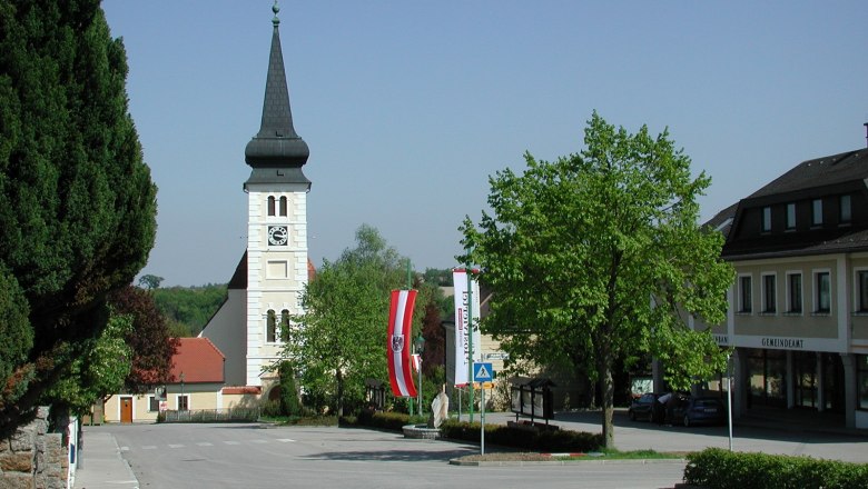 Marktplatz in Ferschnitz mit Kirche und Gemeindebüro.