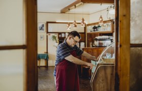 Ein Mann in einer gem&uuml;tlichen Stube bedient eine Musikbox.