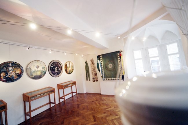 Interior view of a museum with targets on the wall and display cases.