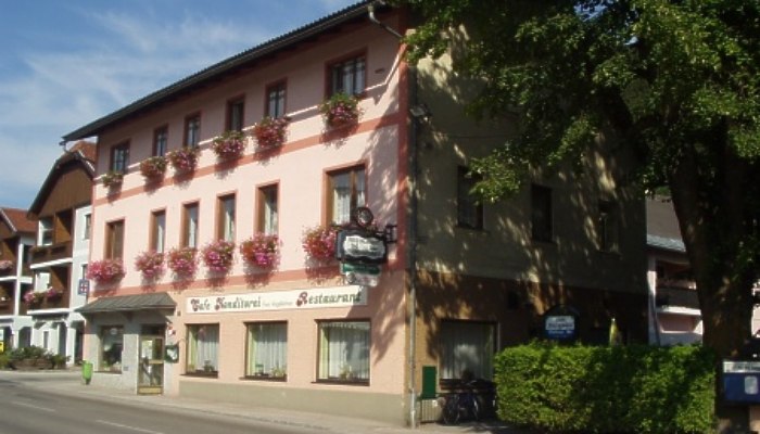 A traditional inn with a pink façade and flower boxes on the windows.