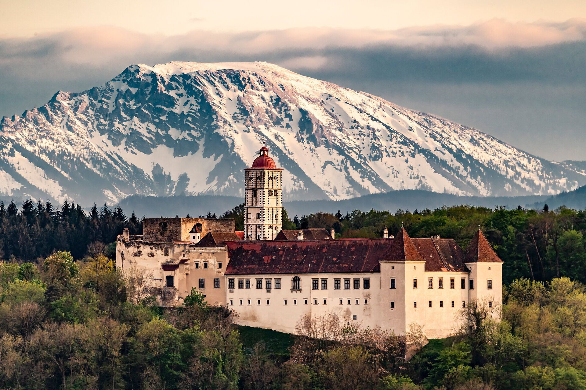 Die majestätische Schallaburg erhebt sich stolz vor der beeindruckenden Kulisse der schneebedeckten Berge. Im Frühling blühen die umliegenden Wiesen in leuchtenden Farben und laden zu einem unvergesslichen Spaziergang ein. Hier verschmelzen Geschichte und Natur zu einem harmonischen Erlebnis.