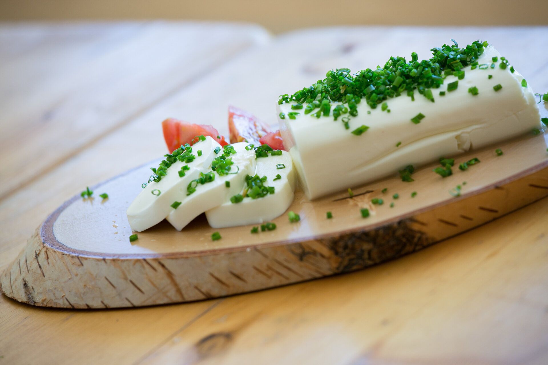 Ein köstlicher Schafkäse, garniert mit frischem Schnittlauch, lädt zu einer genussvollen Jause ein. Die Kombination aus cremigem Käse und aromatischen Kräutern verspricht ein Geschmackserlebnis, das die Sinne verzaubert. Perfekt für eine Pause in der idyllischen Landschaft des Mostviertels.