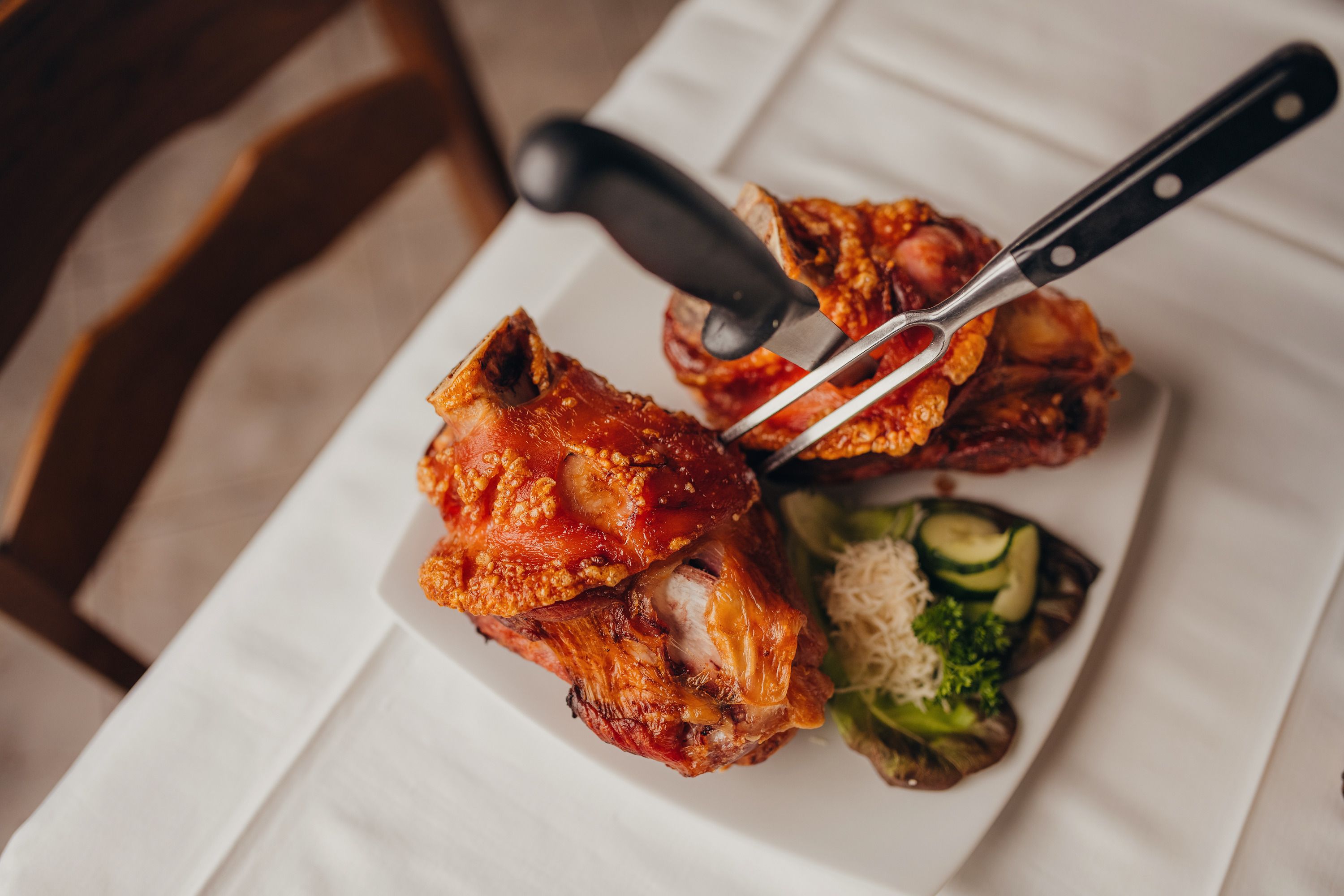 Zwei Schweinshaxen auf einem Teller mit Beilagen.