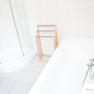Bright bathroom with shower, bathtub and towel rail.