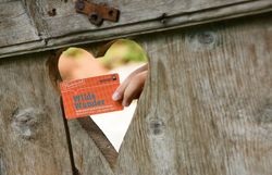 Ein herzförmiger Ausschnitt in einem rustikalen Holzzaun lädt dazu ein, die Schönheit der Natur zu entdecken. Die Wilde Wunder Card verspricht unvergessliche Erlebnisse für die ganze Familie in dieser malerischen Region. Hier, wo die sanften Hügel und üppigen Wiesen aufeinandertreffen, wird jeder Ausflug zum Abenteuer.