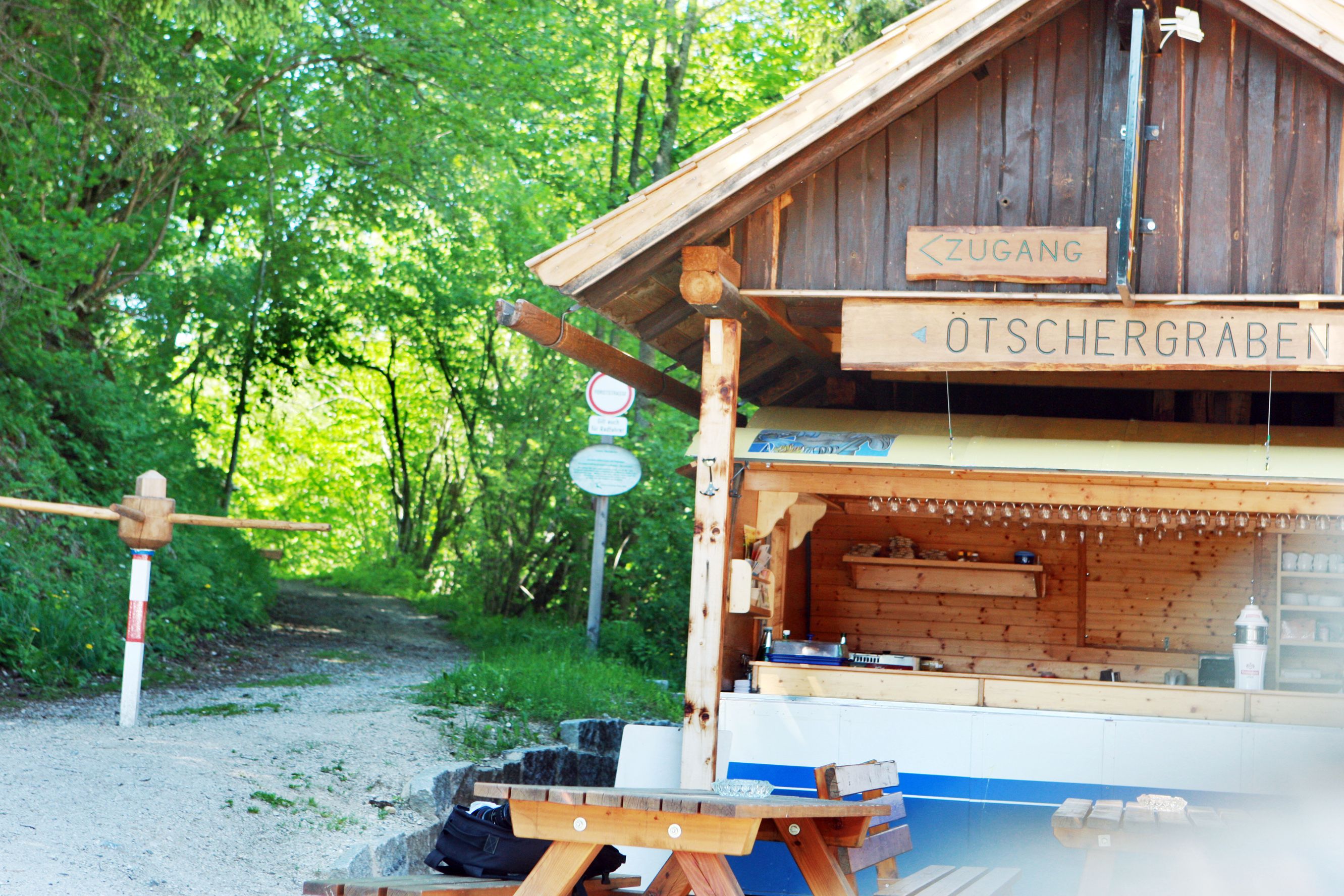 Holzhütte mit Schild 'Ötschergräben' und Waldweg im Hintergrund.
