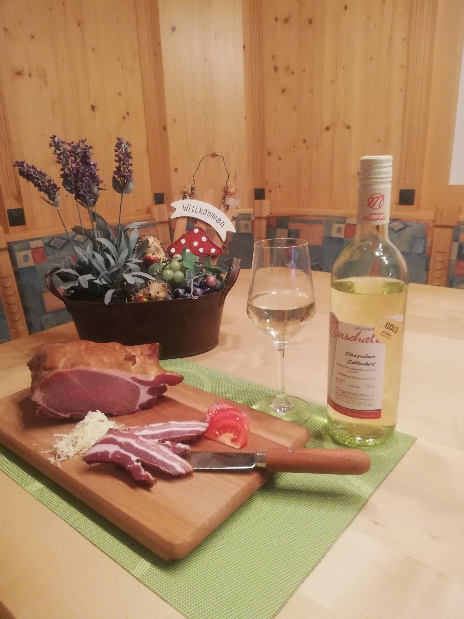 Ein Tisch mit Schinken, Wein und Dekoration.