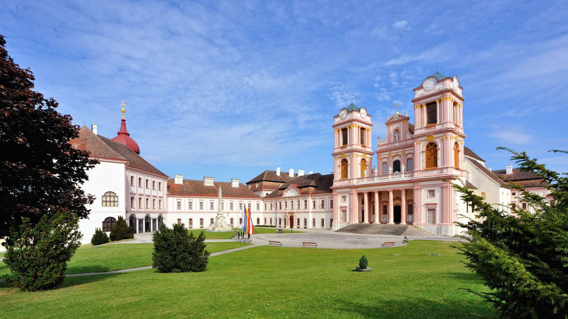 Stift Göttweig mit barocker Architektur und grünem Vorplatz unter blauem Himmel.