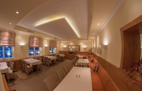 Elegantes Restaurant mit gedeckten Tischen, warmem Licht und stilvoller Dekoration.