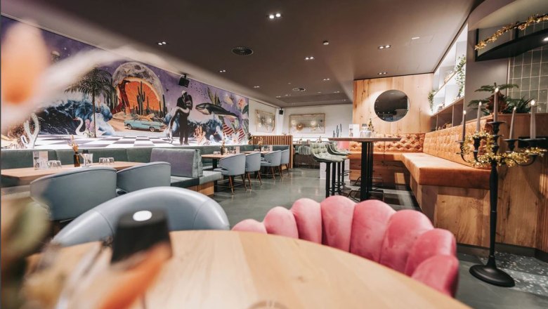 Innenansicht eines stilvollen Restaurants mit moderner Einrichtung und Wandkunst.