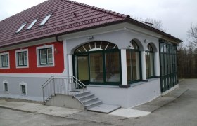 Ein modernes Gebäude mit rotem Dach und roter Fassade.