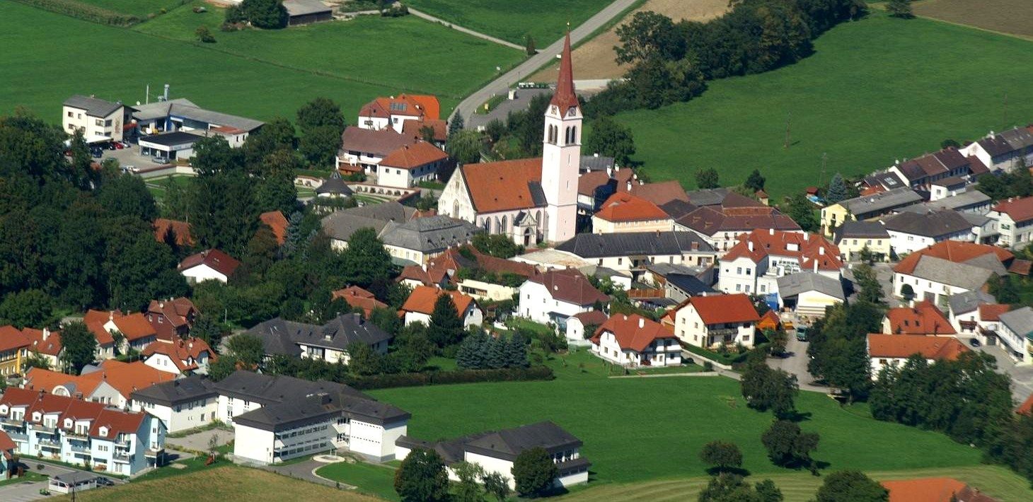 Luftaufnahme der Gemeinde Weistrach mit Kirche und umliegenden Häusern.