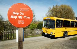 Die Birnbäume blühen in voller Pracht und verleihen der Umgebung einen zauberhaften Duft. Ein nostalgischer Retrobus wartet an der Haltestelle, bereit, die Besucher auf eine unvergessliche Hop On Hop Off Tour durch die malerische Landschaft zu entführen. Genießen Sie die Schönheit der Natur und die frische Luft auf dieser einzigartigen Reise.