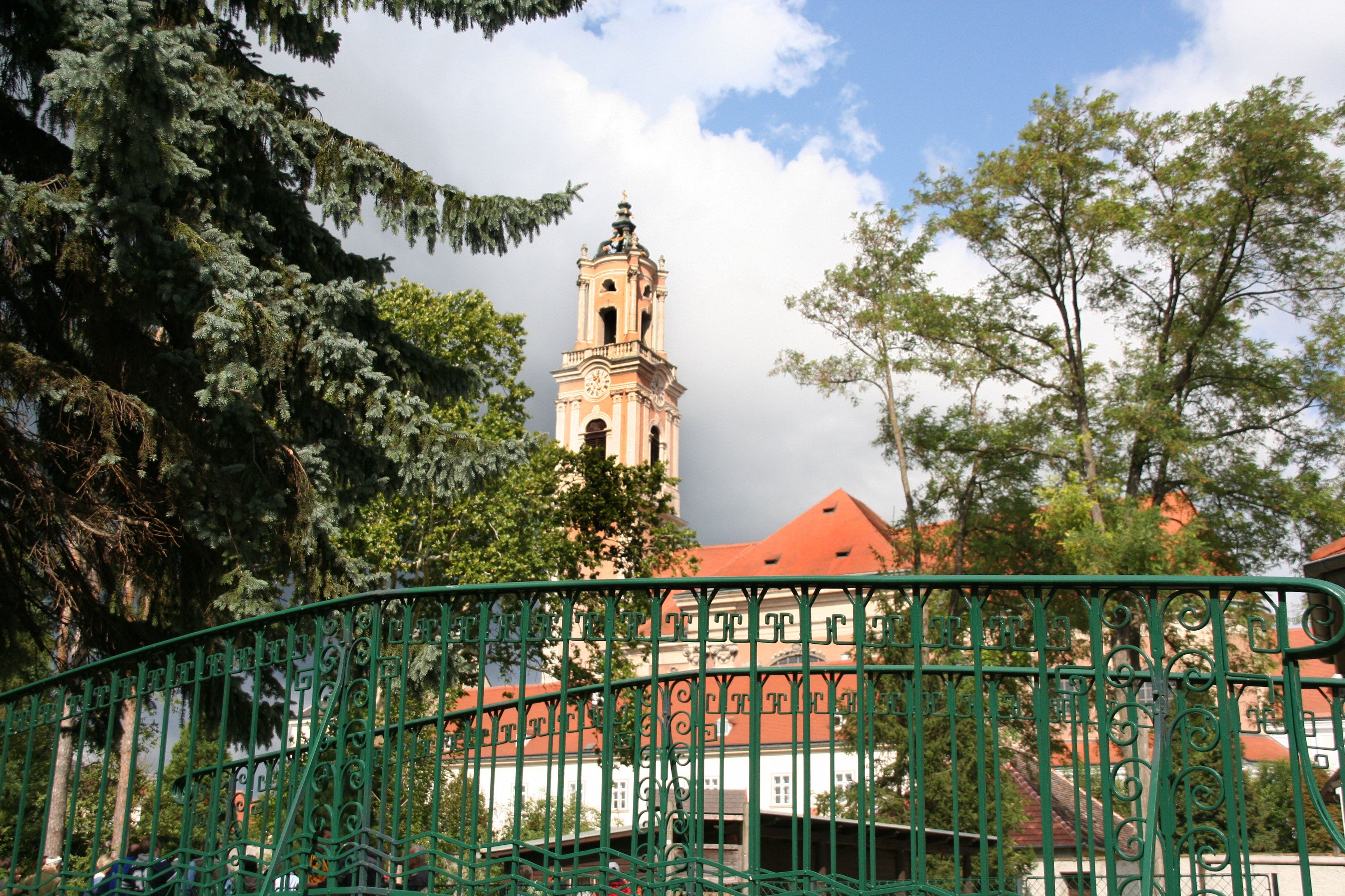 Stift Herzogenburg mit Turm und grünem Zaun im Vordergrund.