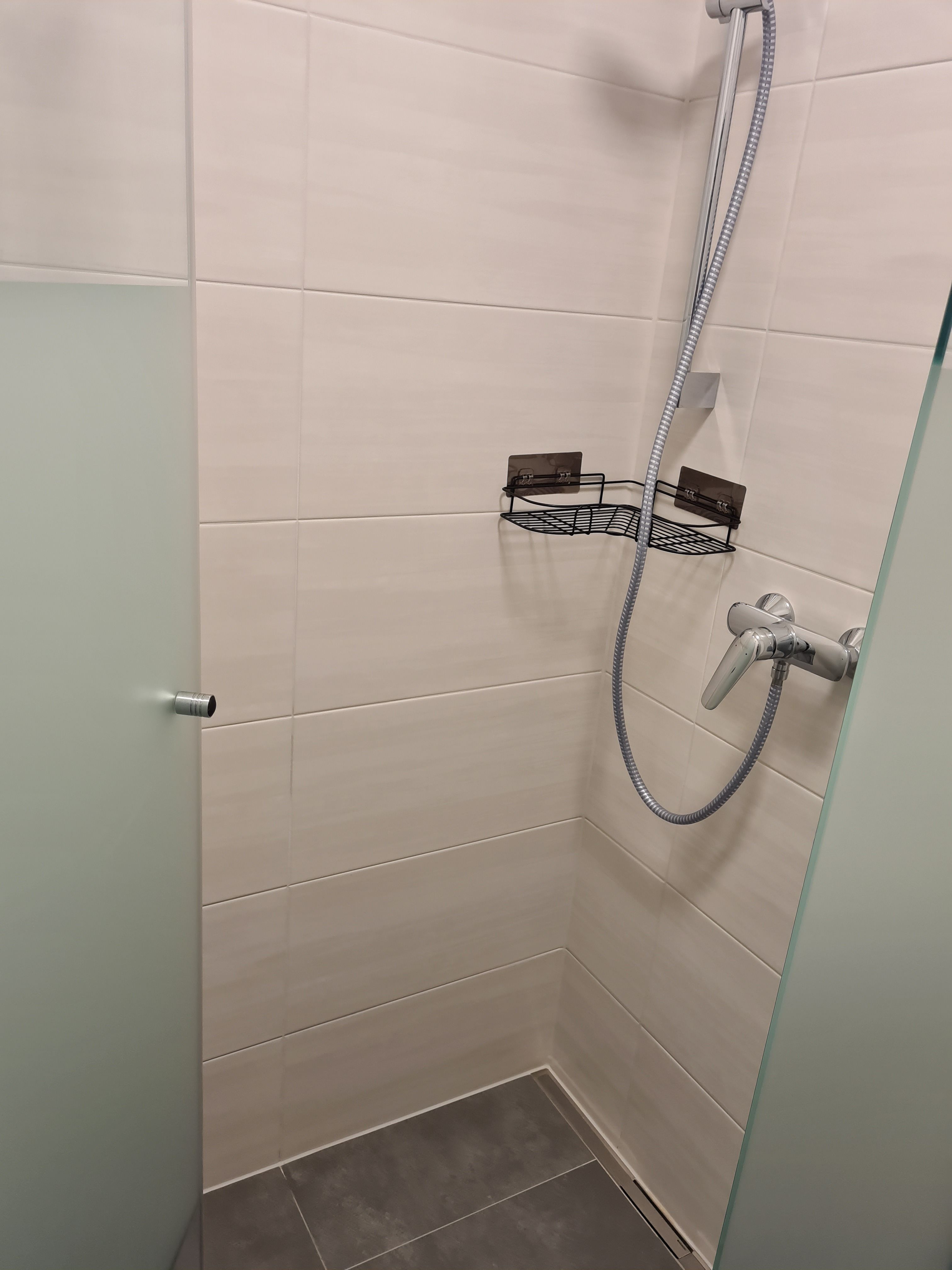 Moderne Dusche mit Glaswand und Duschkopf.