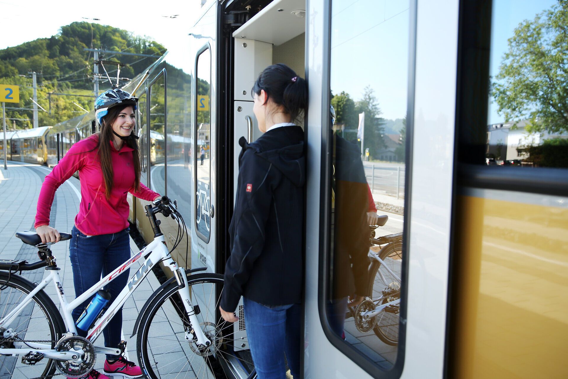 Fröhliche Radfahrerinnen genießen die frische Bergluft und die malerische Landschaft des Pielachtals. Umgeben von sanften Hügeln und üppigem Grün, strahlt die Szene eine einladende Atmosphäre aus, die zum Erkunden einlädt.