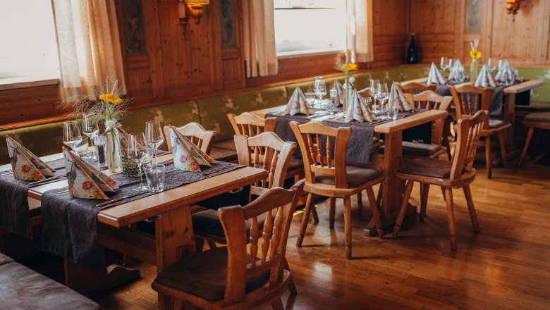 Gemütliches Restaurant mit Holzmöbeln und gedeckten Tischen.