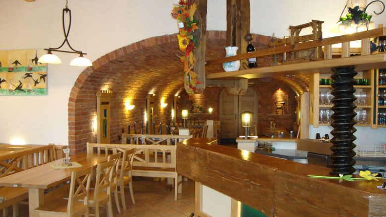 Interior view of a traditional wine tavern with wooden furniture and brick walls.