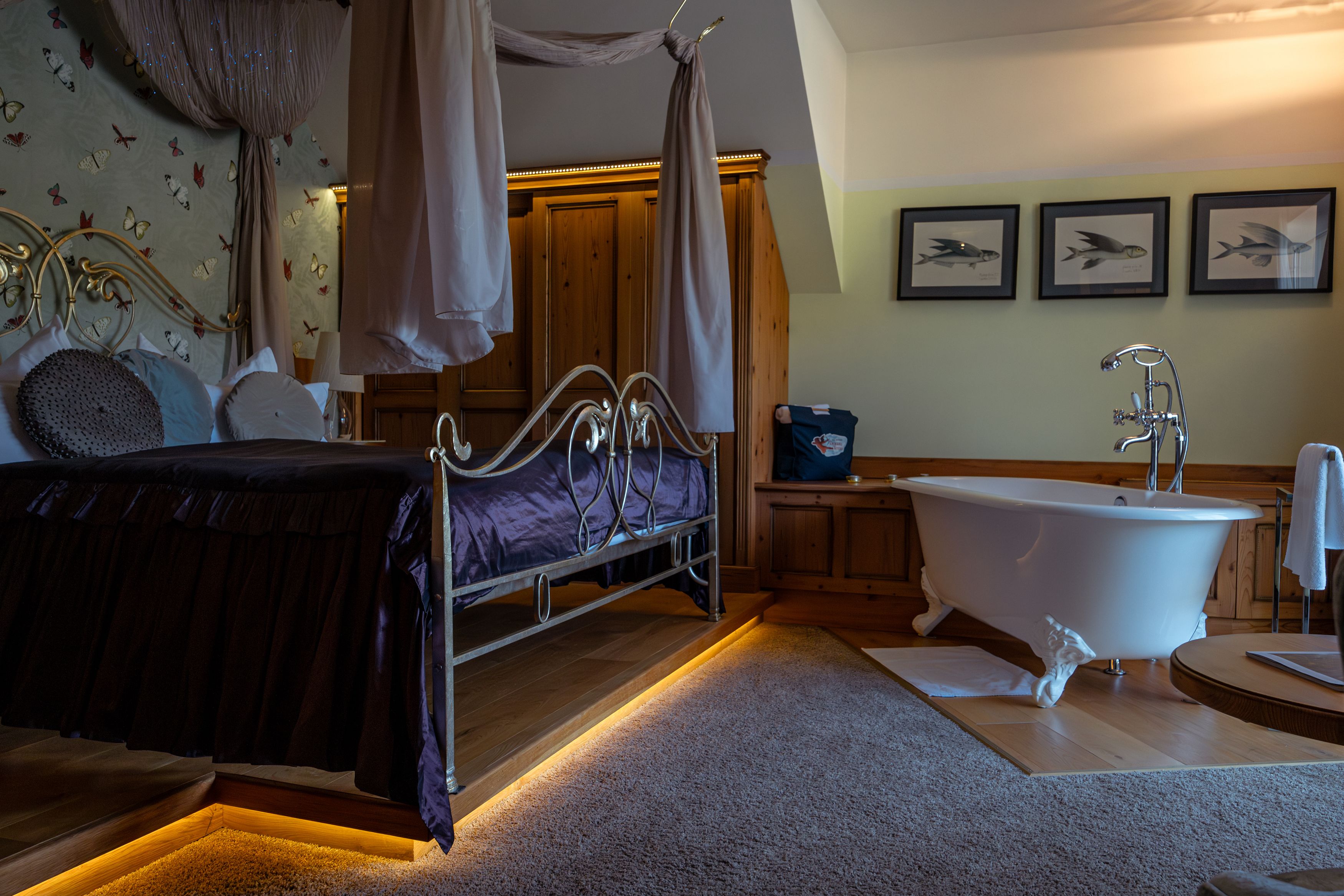 Luxuriöses Hotelzimmer mit Himmelbett und freistehender Badewanne.