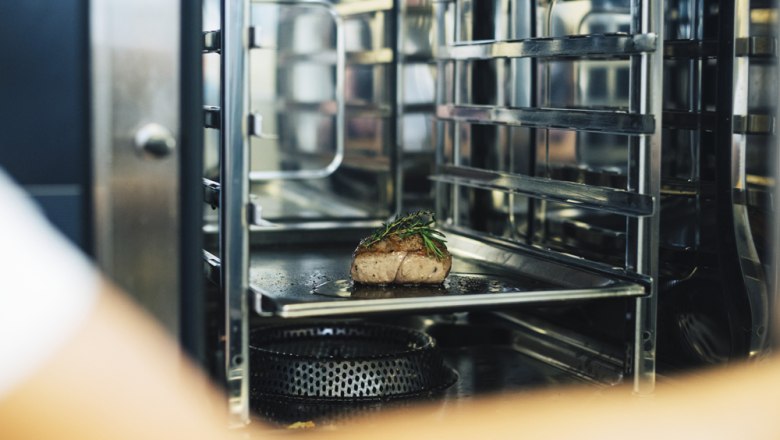 Ein Stück Fleisch mit Kräutern in einem professionellen Ofen.