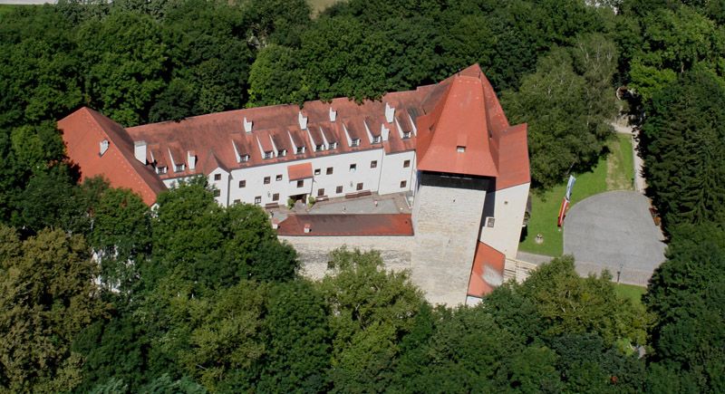 Luftaufnahme von Schloss Ulmerfeld, umgeben von Bäumen.