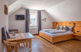 Gem&uuml;tliches Schlafzimmer mit Holzm&ouml;beln und Dachschr&auml;ge.