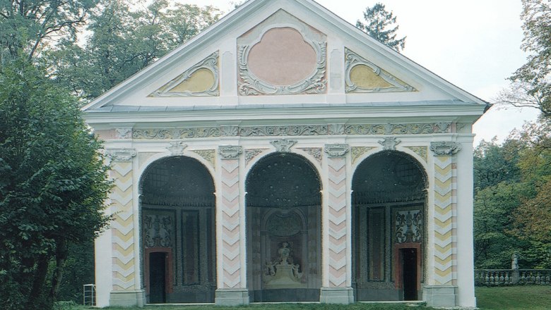 Barockes Gebäude mit drei Bögen und verzierten Fassaden.